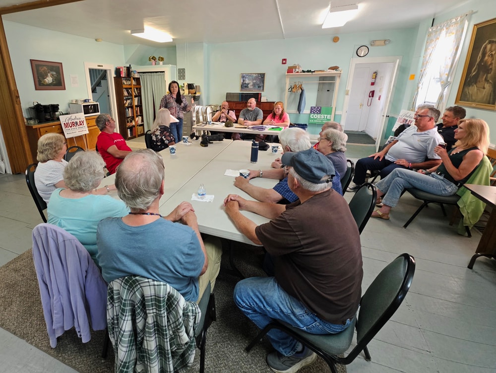Andrea Murray speaking at a community caucus in Sharon
